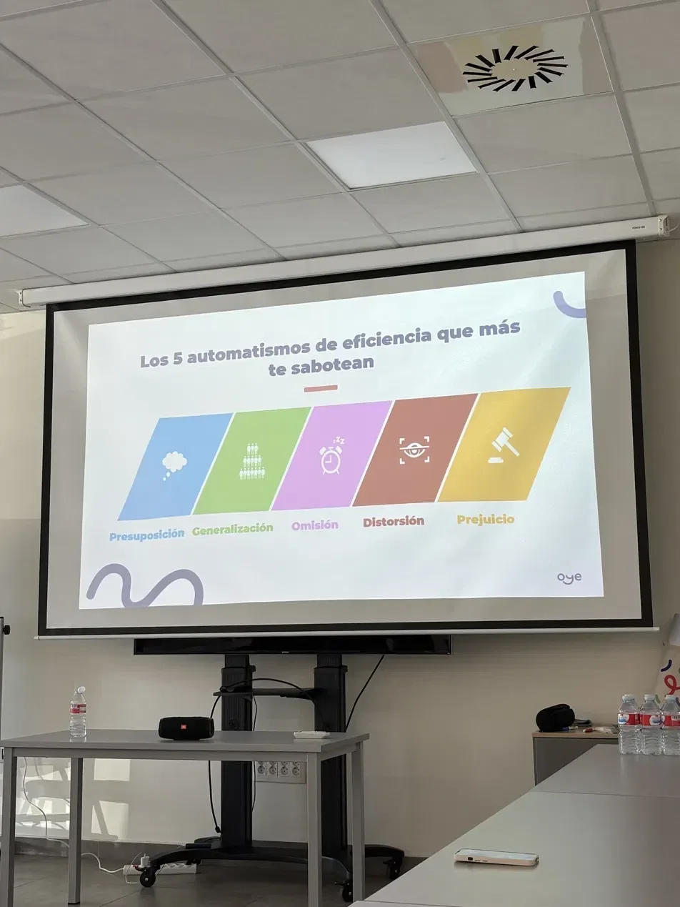 Diapositiva proyectada: Los 5 automatismos de eficiencia que más te sabotean, con cinco bandas de color